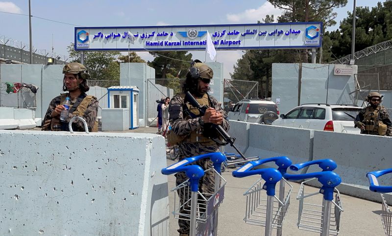 &copy; Reuters. مقاتلان من طالبان يقفان في حراسة مدخل مطار حامد كرزاي الدولي في كابول بعد انسحاب القوات الأمريكية يوم 31 أغسطس آب 2021. صورة لرويترز.
