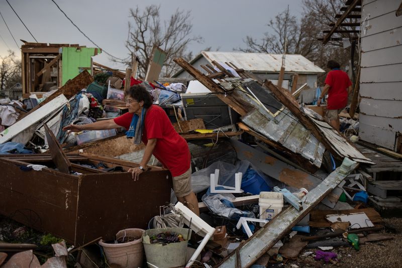© Reuters. شقيقتان مسنتان تبحثان عن أغراض شخصية وسط حطام منزلهما الذي دمره الإعصار أيدا في جولدن ميدو بولاية لويزيانا الأمريكية في صورة التُقطت يوم الأربعاء. تصوير: ادريس لطيف - رويترز.
