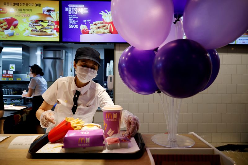 &copy; Reuters. FILE PHOTO: An employee of McDonald's serves a BTS meal, which is inspired and promoted by K-pop boy band BTS, during lunch hour at its restaurant in Seoul, South Korea, May 27, 2021.  REUTERS/Kim Hong-Ji//File Photo