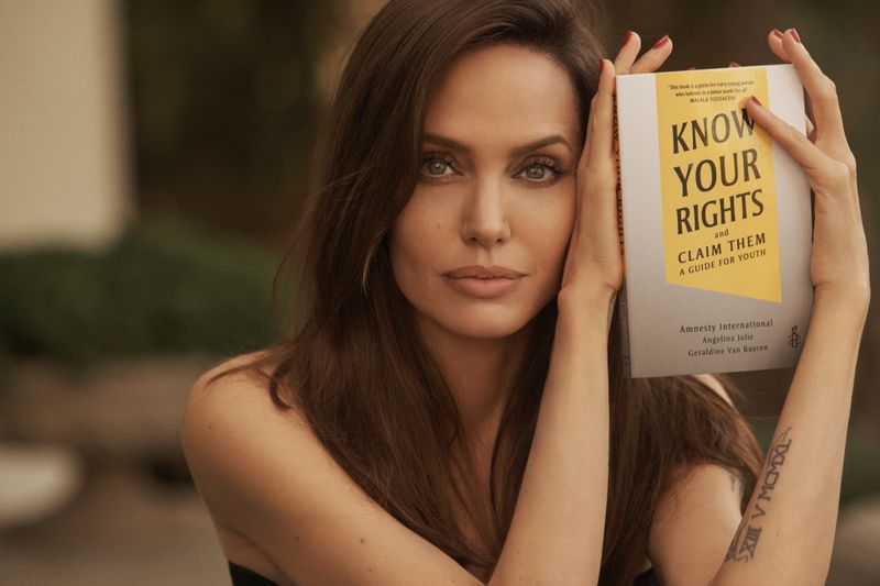 &copy; Reuters. La actriz Angelina Jolie posa con el libro "Know Your Rights (And Claim Them)" en esta fotografía sin fecha específica vía  Amnesty International/Lachlan Bailey/Handout via REUTERS
