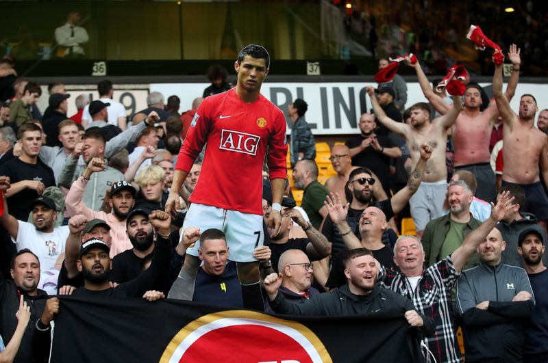&copy; Reuters. Ago 29, 2021 
Foto de archivo de hinchas del Manchester United celebrando con un cartel de Cristiano Ronaldo tras la victoria sobre Wolverhampton Wanderers
Action Images via Reuters/Carl Recine 
