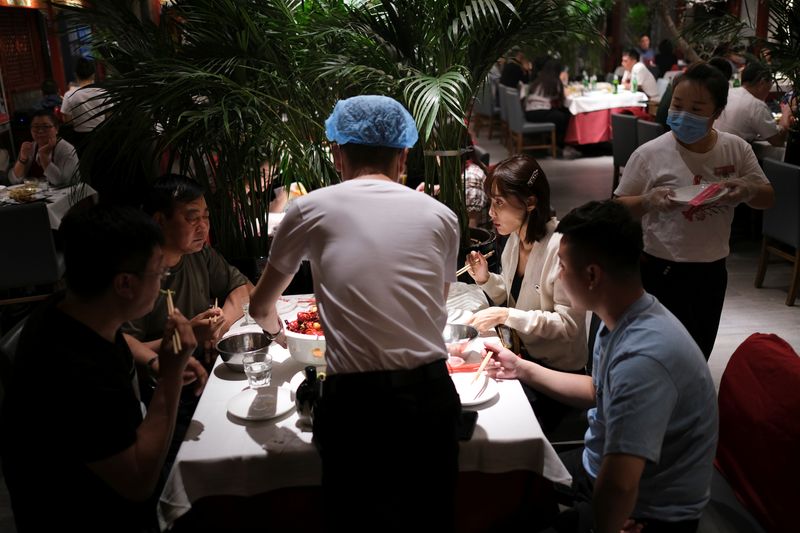 &copy; Reuters. FILE PHOTO: People enjoy their meal at a restaurant, following an outbreak of the coronavirus disease (COVID-19), in Beijing, China May 7, 2020. REUTERS/Carlos Garcia Rawlins