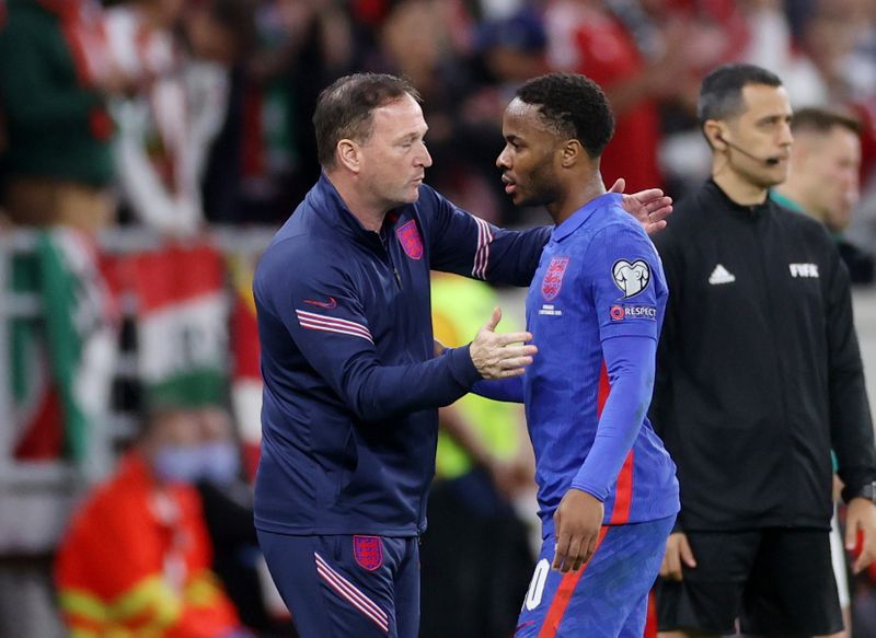 © Reuters. FILE PHOTO: Soccer Football - World Cup - UEFA Qualifiers - Group I - Hungary v England - Puskas Arena, Budapest, Hungary - September 2, 2021 England's Raheem Sterling with coach Steve Holland after the match REUTERS/Carl Recine