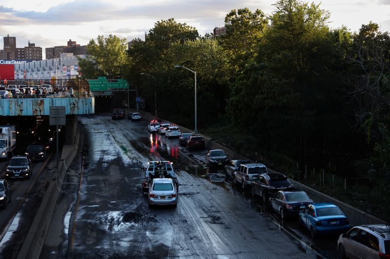© Reuters. FILE PHOTO: A tow truck clears a car abandoned on the Major Deegan Expressway after the remnants of Tropical Storm Ida brought drenching rain, flash floods and tornadoes to parts of the northern mid-Atlantic, in the Bronx borough of New York City, U.S., September 2, 2021. REUTERS/Caitlin Ochs