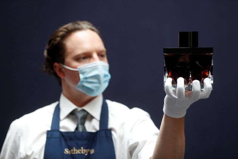 &copy; Reuters. A gallery assistant holds a sample bottle of Gordon & MacPhail whisky, which is up for sale at Sotheby's in London, Britain, September 2, 2021. REUTERS/Matthew Childs