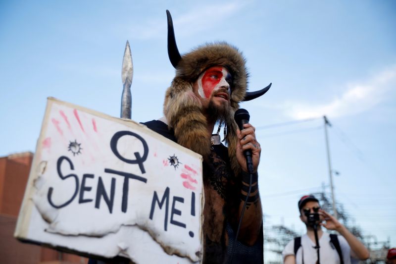 &copy; Reuters. FILE PHOTO: Jacob Chansley, holding a sign referencing QAnon, speaks as supporters of U.S. President Donald Trump gather to protest about the early results of the 2020 presidential election, in front of the Maricopa County Tabulation and Election Center (