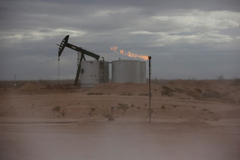 © Reuters. FILE PHOTO: Dust blows around a crude oil pump jack and flare burning excess gas at a drill pad in the Permian Basin in Loving County, Texas, U.S. November 25, 2019. REUTERS/Angus Mordan/File Photo