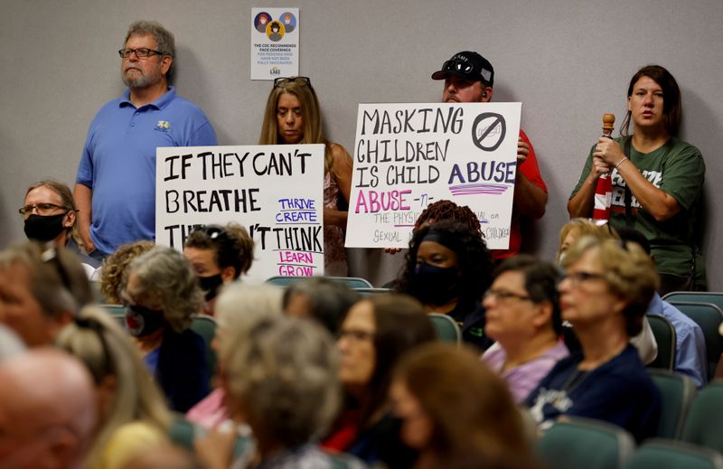 &copy; Reuters. Pessoas com cartazes durante reunião escolar do condado de Lake, na Flórida
02/09/2021
REUTERS/Joe Skipper