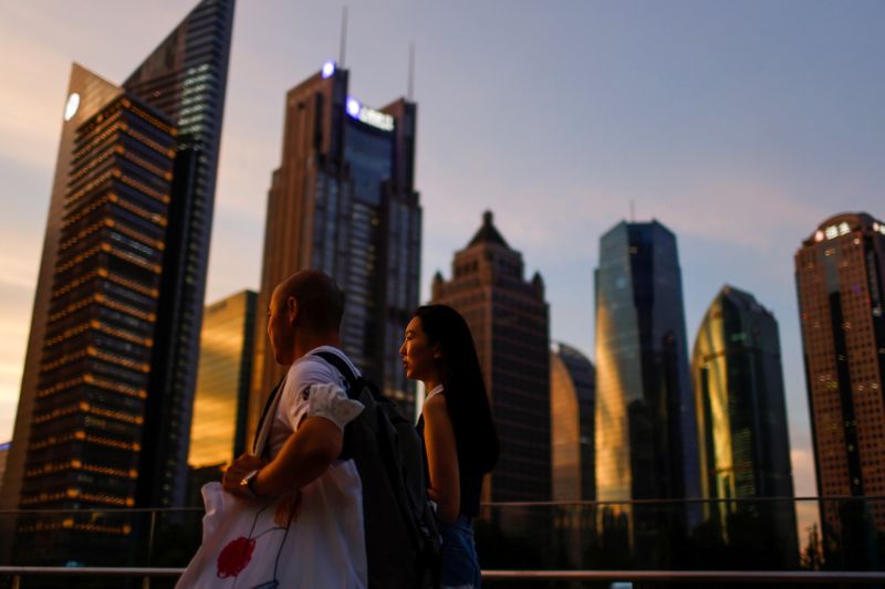 &copy; Reuters. FILE PHOTO: People walk in Lujiazui financial district during sunset in Pudong, Shanghai, China July 13, 2021. Picture taken July 13, 2021. REUTERS/Aly Song 