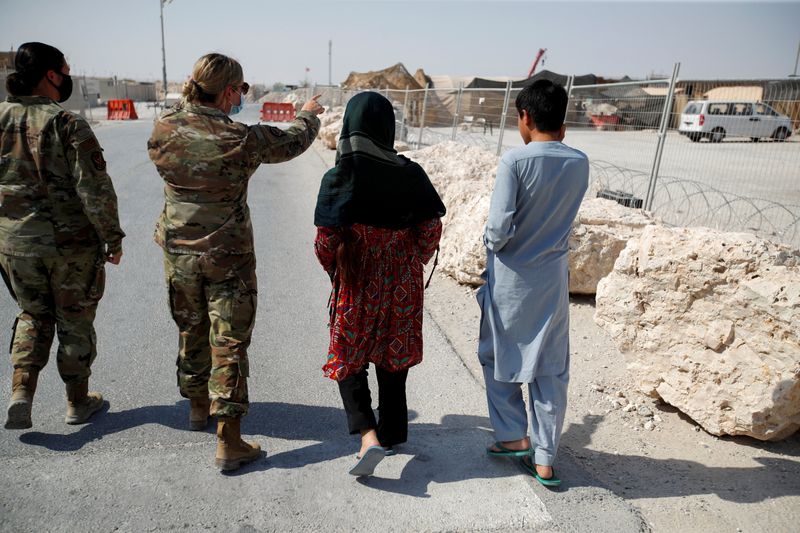 &copy; Reuters. A U.S. military officer gestures as she stands next to Afghan evacuees at Al Udeid airbase in Doha, Qatar, September 4, 2021. REUTERS/Hamad I Mohammed
