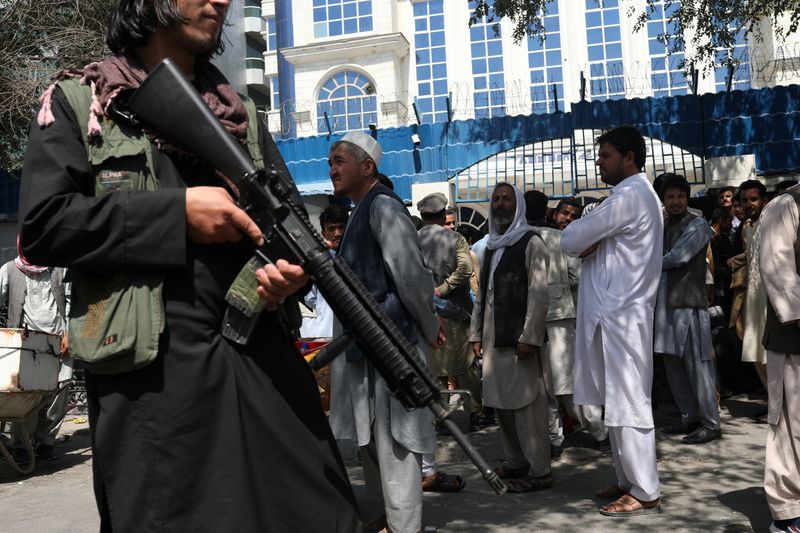 &copy; Reuters. 　アフガニスタンのイスラム主義組織タリバンは４日、唯一制圧していない北東部パンジシール州を支配下におさめようと抵抗勢力と衝突した。写真は首都カブールの銀行の前でライフルを