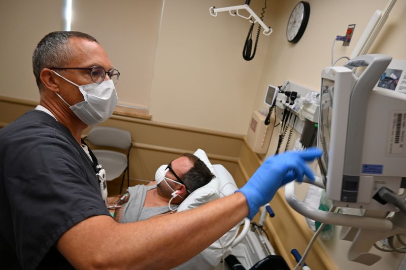 &copy; Reuters. FILE PHOTO: Nurse Chris Prott examines a patient in the urgent care department at the Iron Mountain VA Medical Center in Iron Mountain, Michigan, U.S., August 25, 2021. John Jamison/Handout via REUTERS 