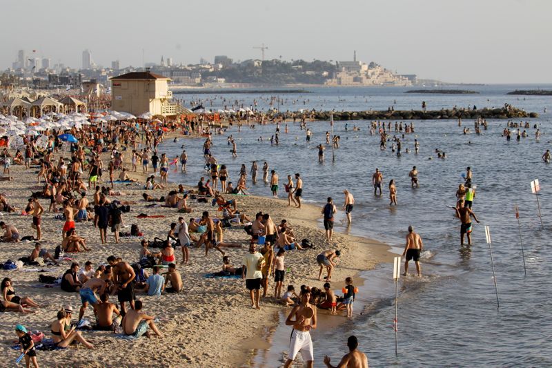 &copy; Reuters. FILE PHOTO: Beachgoers hang out on the shore of the Mediterranean sea in Tel Aviv as coronavirus disease (COVID-19) restrictions eased in Israel May 21, 2020. REUTERS/Amir Cohen
