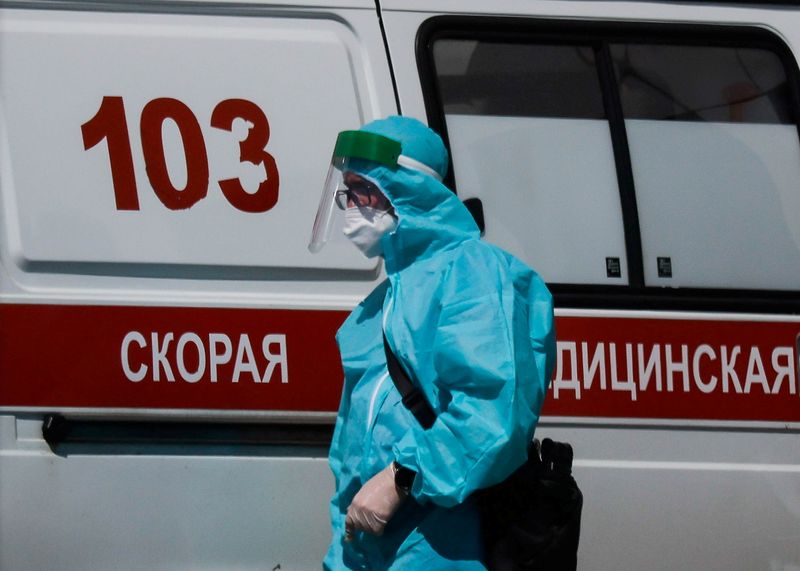&copy; Reuters. FOTO DE ARCHIVO: Un trabajador médico con un equipo de protección individual junto a una ambulancia en el exterior de un hospital para pacientes de COVID-19 en Moscú, Rusia, el 16 de junio de 2021. REUTERS/Maxim Shemetov