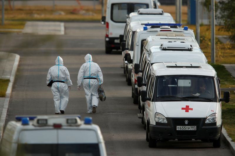 © Reuters. Medical specialists wearing protective gear walk past ambulances outside a hospital for patients infected with the coronavirus disease (COVID-19) on the outskirts of Moscow, Russia October 15, 2020. REUTERS/Maxim Shemetov