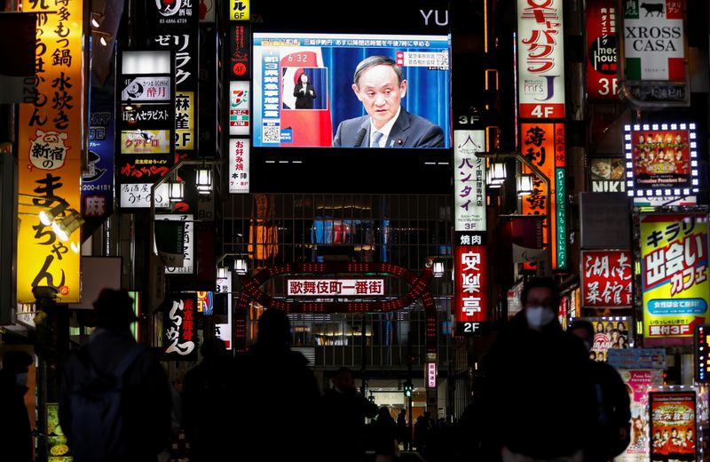 &copy; Reuters. Un grande schermo su un edificio mostra una trasmissione in diretta del Primo Ministro giapponese Yoshihide Suga, a Tokyo, Giappone gennaio 7, 2021. REUTERS/Issei Kato