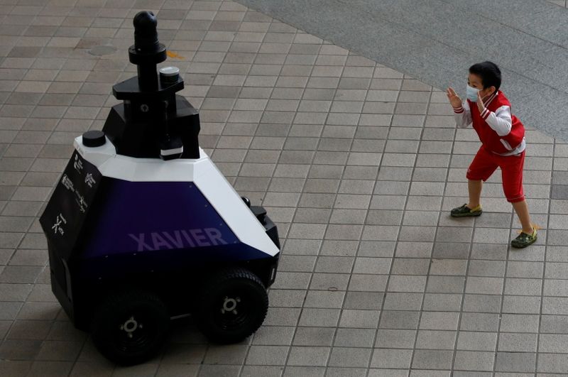 &copy; Reuters. Menino brinca em frente a robô usado em Cingapura para patrulha. 6/9/2021. REUTERS/Edgar Su