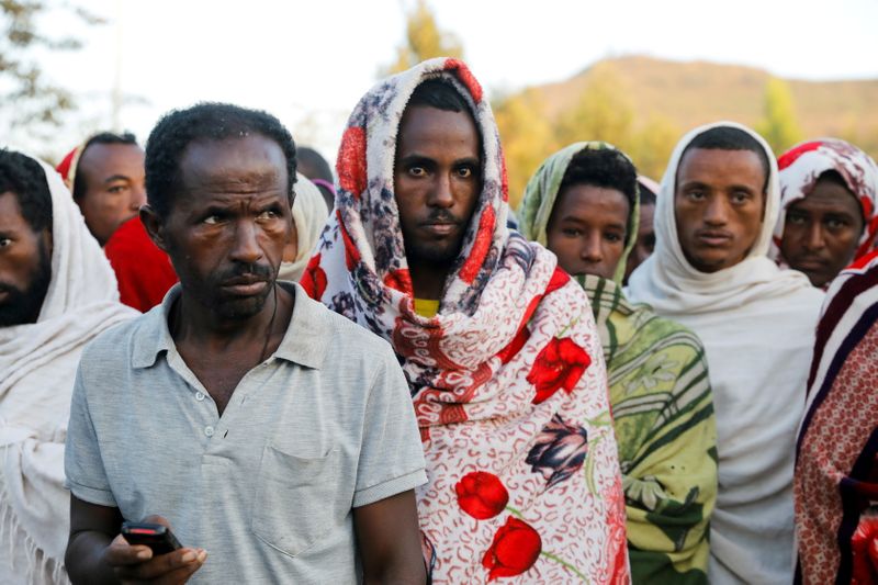 &copy; Reuters. رجال يقفون في طابور للحصول على معونات غذائية في اقليم تيجري الإثيوبي يوم 15 مارس اذار 2021. تصوير: باز راتنر - رويترز. 