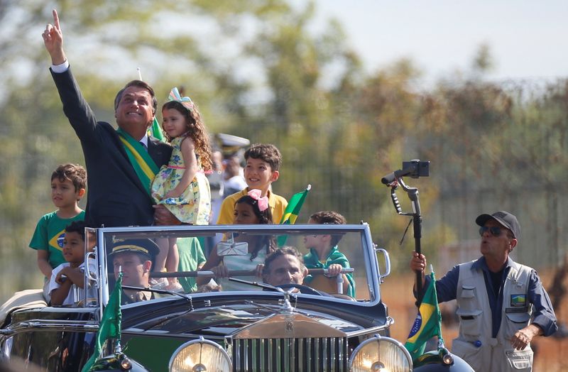 © Reuters. Bolsonaro se desloca para cerimônia pelo Dia da Independência, em Brasília, carro conduzido pelo ex-piloto Nelson Piquet
7/9/2021 REUTERS/Adriano Machado