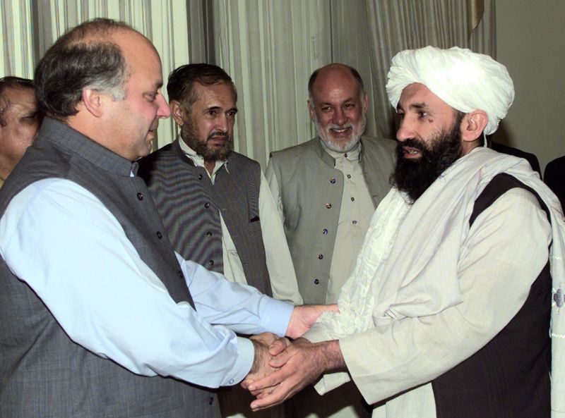 &copy; Reuters. الملا حسن أخوند (في اليمين) يصافح رئيس الوزراء الباكستاني السابق نواز شريف. صورة من ارشيف رويترز.