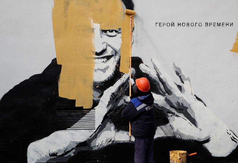&copy; Reuters. A worker paints over a graffiti depicting jailed Russian opposition politician Alexei Navalny in Saint Petersburg, Russia April 28, 2021. The graffiti reads: "The hero of the new age". REUTERS/Anton Vaganov