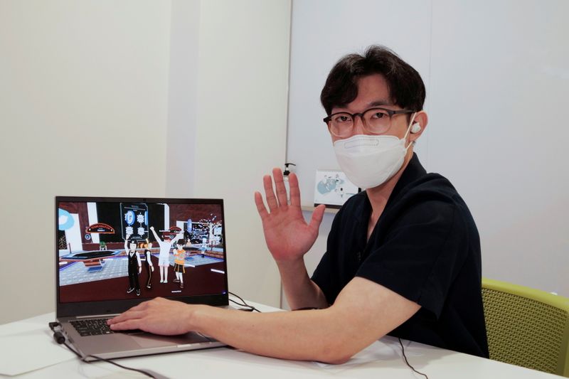 &copy; Reuters. Shaun poses for photographs with a laptop showing his avatar in Decentraland in Seoul, South Korea, August 13, 2021. Picture taken on August 13, 2021.  REUTERS/Daewoung Kim