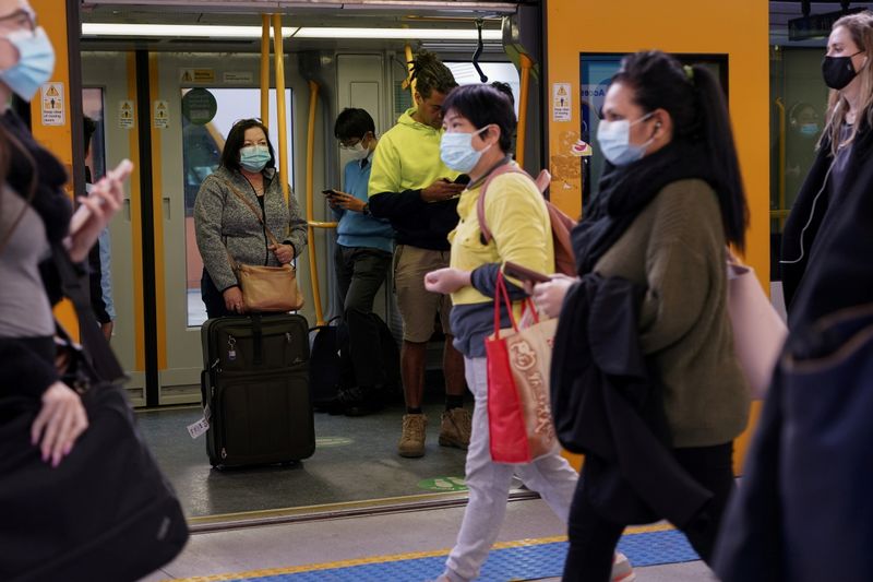 © Reuters. FILE PHOTO: Commuters wear protective face masks on public transit at Central Station following the implementation of new public health regulations from the state of New South Wales, as the city grapples with an outbreak of the coronavirus disease (COVID-19) in Sydney, Australia, June 23, 2021. REUTERS/Loren Elliott/File Photo