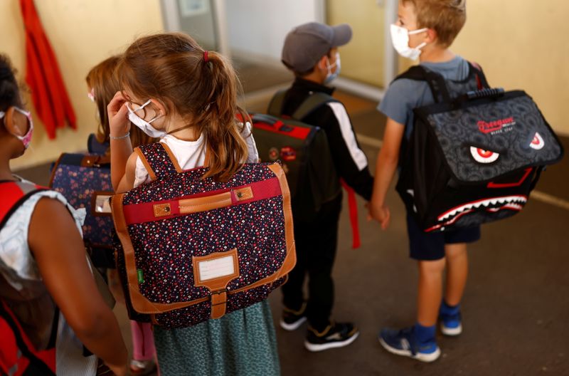 &copy; Reuters. 　９月８日、ロイターの集計によると、新型コロナウイルスの感染者は世界全体で２億２１７９万人を超え、死者は４７６万０３４７人となった。写真は夏休み明けに学校に着いた子供たち