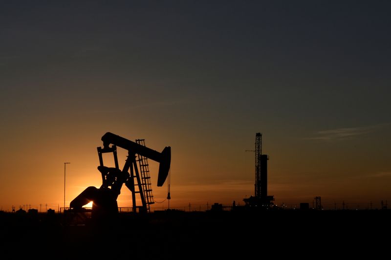 &copy; Reuters. A pump jack operates in front of a drilling rig at sunset in an oil field in Midland, Texas U.S. August 22, 2018. Picture taken August 22, 2018. REUTERS/Nick Oxford