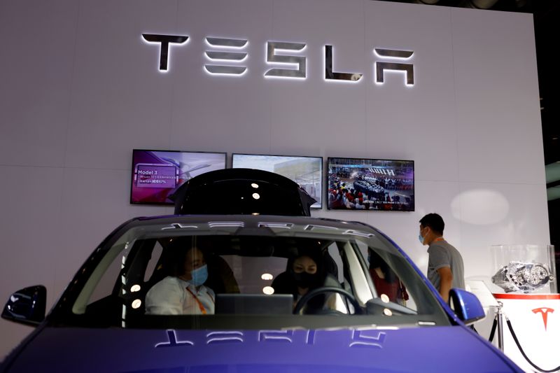 © Reuters. FILE PHOTO: People check a Tesla Model Y electric vehicle (EV) displayed at its booth during the 2021 China International Fair for Trade in Services (CIFTIS) in Beijing, China September 4, 2021. REUTERS/Florence Lo/File Photo