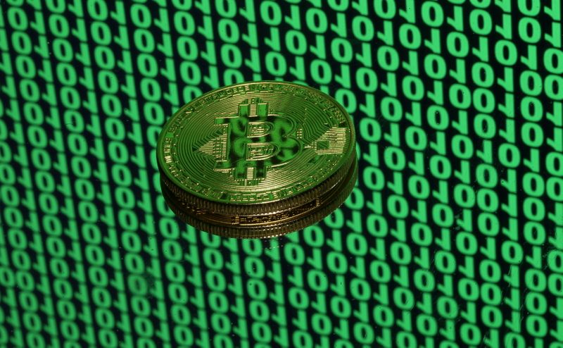 &copy; Reuters. FILE PHOTO: A token of the virtual currency Bitcoin is seen placed on a monitor that displays binary digits in this illustration picture, December 8, 2017. REUTERS/Dado Ruvic/Illustration