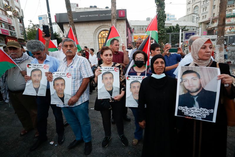 &copy; Reuters. أقارب السجناء الفارين من سجن إسرائيلي يرفعون صورهم في رام الله بالضفة الغربية يوم الأربعاء. رويترز