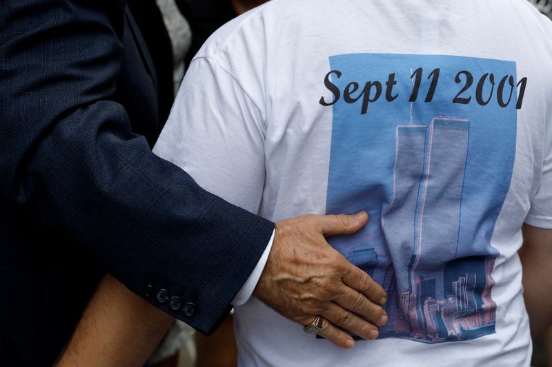© Reuters. مشارك في إحياء ذكرى هجمات 11 سبتمبر يرتدي قميصا عليه صورة برجي التجارة في نيويورك. رويترز