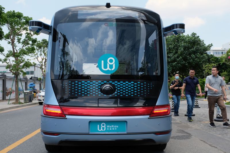 &copy; Reuters. FILE PHOTO: People walk past a WeRide autonomous driving robobus near its office in Guangzhou, Guangdong province, China May 11, 2021. Picture taken May 11, 2021. REUTERS/Yilei Sun