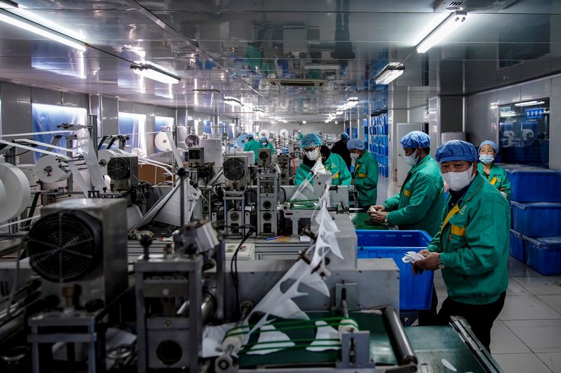 © Reuters. Workers are seen on a production line manufacturing masks at a factory in Shanghai, China January 31, 2020. Picture taken January 31, 2020. REUTERS/Aly Song