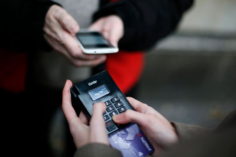 &copy; Reuters. FILE PHOTO: Big Issue vendor Simon Mott demonstrates using his Chip and Pin device outside South Kensington Tube Station in London November 28, 2013. REUTERS/Stefan Wermuth