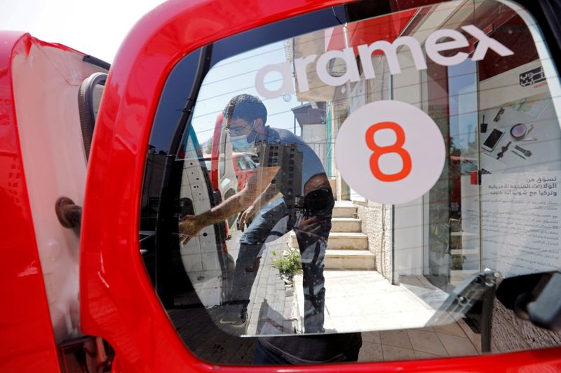 &copy; Reuters. FILE PHOTO: A delivery staff member wearing a protective mask unloads parcels from a vehicle outside Aramex office amid the coronavirus disease (COVID-19) crisis, in Bethlehem in the Israeli-occupied West Bank July 19, 2020. REUTERS/Mussa Qawasma