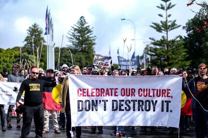&copy; Reuters. FILE PHOTO: Aboriginal groups' members carrying a banner march to protest against what they say is a lack of detail and consultation on new heritage protection laws, after the Rio Tinto mining group destroyed ancient rock shelters for an iron ore mine las