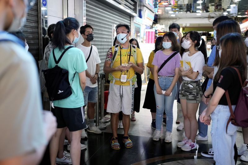 &copy; Reuters. Tour guide Michael Tsang speaks to tourists during a tour visiting refugee communities in Hong Kong, China August 21, 2021. Picture taken August 21, 2021. REUTERS/Tyrone Siu