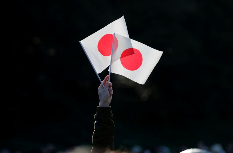 &copy; Reuters. FILE PHOTO: A well-wisher holds Japan's national flags during Emperor Naruhito's public appearance for New Year celebrations at the Imperial Palace in Tokyo, Japan, January 2, 2020. REUTERS/Kim Kyung-Hoon