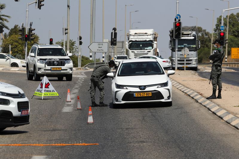 &copy; Reuters. أحد أفراد قوات الأمن الإسرائيلية يستوقف سيارة في نقطة تفتيش بالضفة الغربية يوم الخميس. تصوير: عمار عوض - رويترز. 