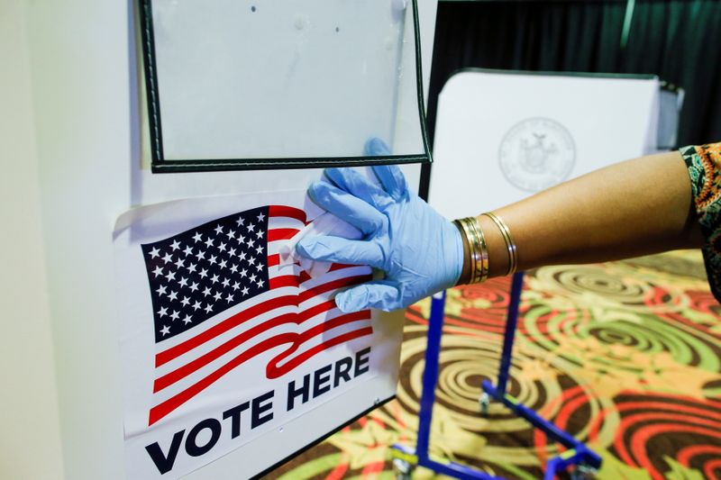 &copy; Reuters. FILE PHOTO: An electoral worker disinfects a booth at the voting center on the first day of early voting for the New York Primary election at Resorts World Casino in Queens, New York City, U.S., June 12, 2021. REUTERS/Eduardo Munoz/File Photo