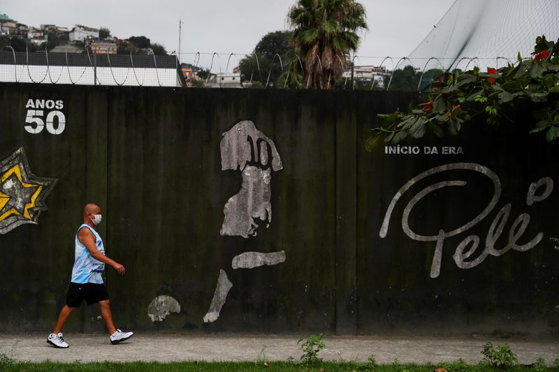 &copy; Reuters. Foto de archivo de un hombre caminando frenta a un mural en honor a Pelé en Santos. 
Oct 20, 2020. REUTERS/Amanda Perobelli