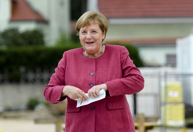 &copy; Reuters. FILE PHOTO: German Chancellor Angela Merkel holds a roll of paper that will go inside a time capsule during the 750th city anniversary celebrations in Burgergarten, in Templin, Germany September 10, 2021.  REUTERS/Annegret Hilse/File Photo