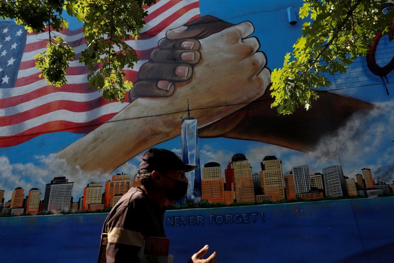 &copy; Reuters. FILE PHOTO: A man walks by a 9/11 memorial mural in the Bronx borough of New York City, U.S., September 10, 2021.  REUTERS/Shannon Stapleton/File Photo