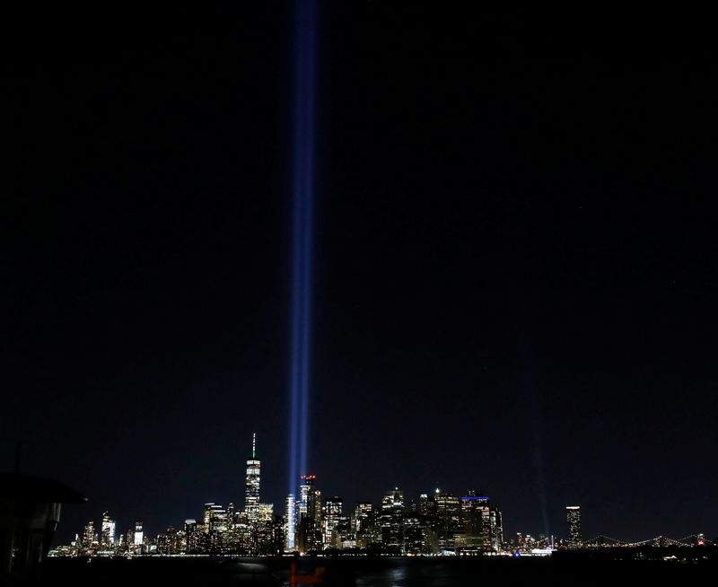 &copy; Reuters. People take photos of the Tribute in Light installation and the World Trade Center from a Staten Island Ferry ahead of the 20th anniversary of the September 11 attacks in New York City, U.S., September 10, 2021.  REUTERS/Mario Anzuoni