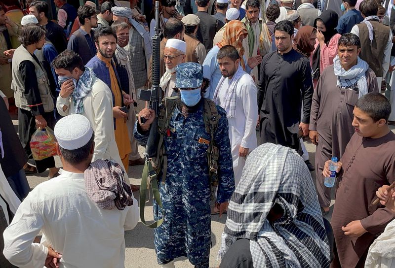 &copy; Reuters. أحد أفراد قوات الأمن التابعة لطالبان يقف شاهرا سلاحه بين أناس يمرون في أحد شوارع العاصمة الأفغانية كابول يوم 4 سبتمبر أيلول 2021. تصوير: رويترز