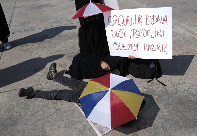&copy; Reuters. A woman holds a placard reading "Freedom is not free. We are ready to pay for it" during a protest against official coronavirus-related mandates including vaccinations, tests and masks, in Istanbul, Turkey September 11, 2021. REUTERS/Murad Sezer