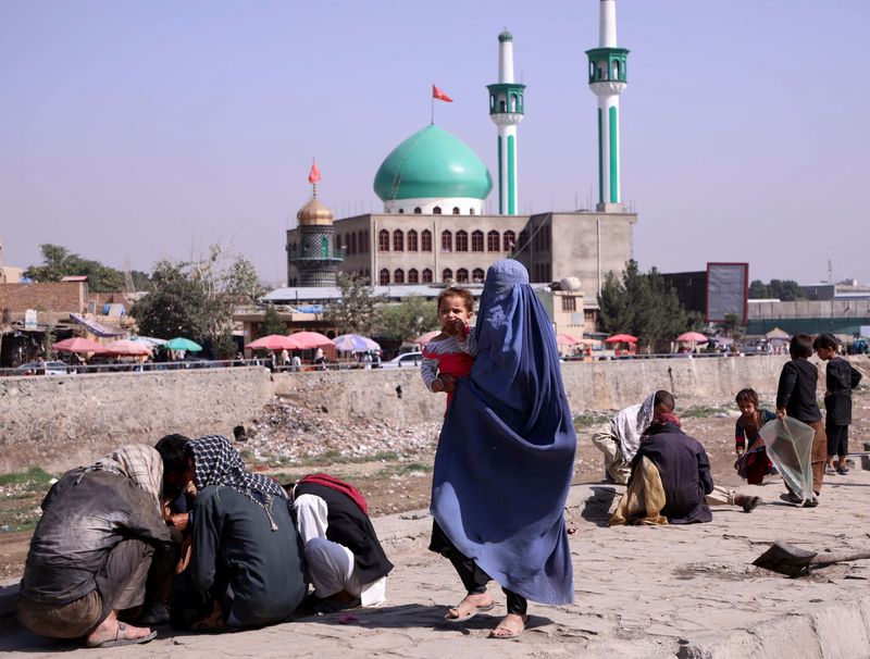 &copy; Reuters. امرأة ترتدي البرقع تحمل طفلها تسير في أحد شوارع كابول يوم الرابع من سبتمبر أيلول 2021 - رويترز