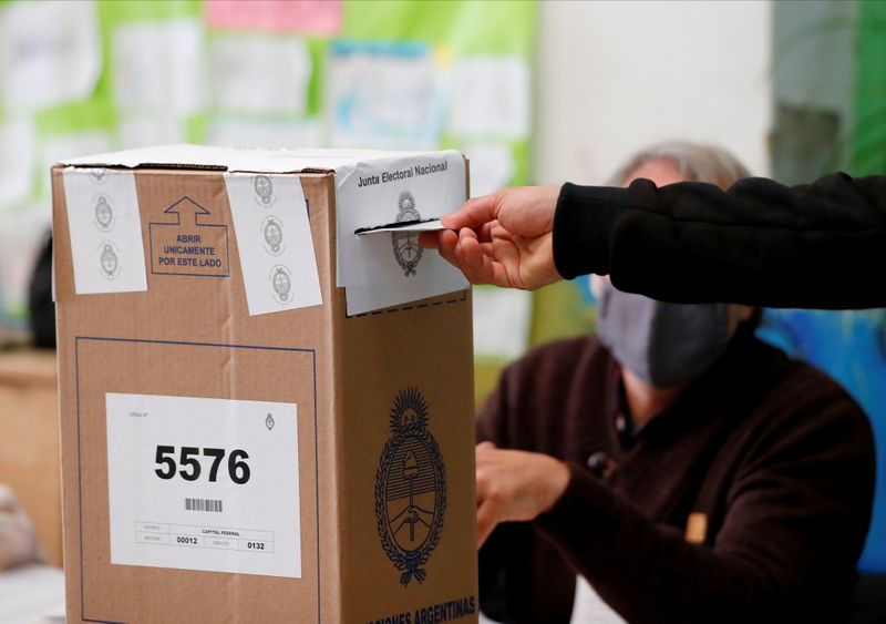 &copy; Reuters. Un hombre pone su voto en una urna durante las elecciones primarias del domingo en Buenos Aires, Argentina. 12 sept, 2021. REUTERS/Agustin Marcarian